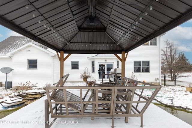 snow covered patio with a gazebo and grilling area