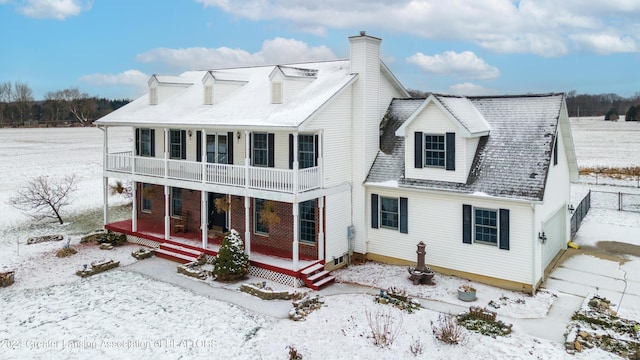 snow covered property with a porch