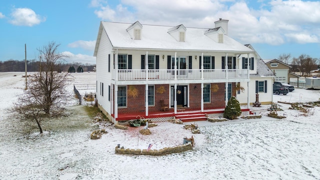 snow covered rear of property featuring a porch