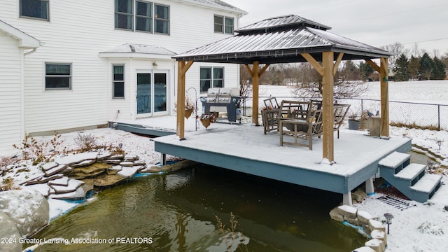 snow covered deck with a gazebo and area for grilling