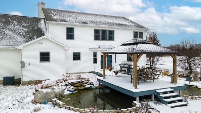 snow covered property with a gazebo, a deck, and central air condition unit