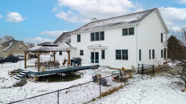 snow covered house with a gazebo and a wooden deck