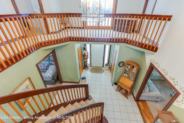 stairs with tile patterned flooring and a high ceiling