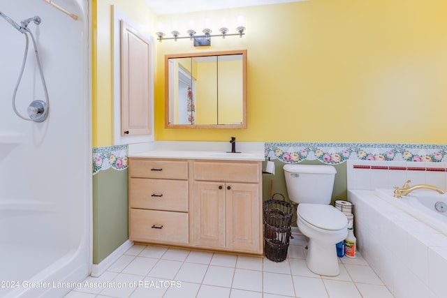 bathroom featuring tile patterned flooring, vanity, a relaxing tiled tub, and toilet