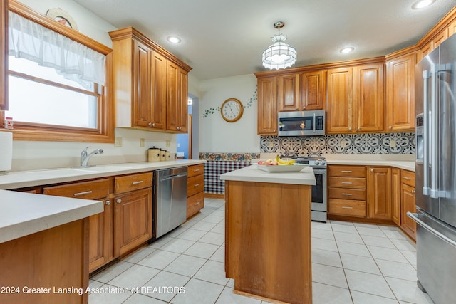 kitchen featuring a center island, light tile patterned floors, pendant lighting, and appliances with stainless steel finishes