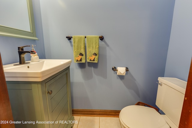 bathroom with toilet, vanity, and tile patterned floors