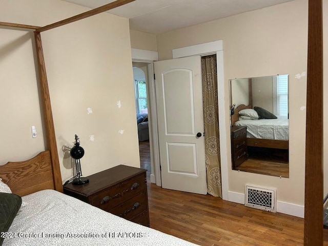 bedroom with wood-type flooring and a closet