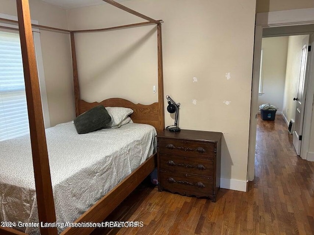 bedroom with dark wood-type flooring