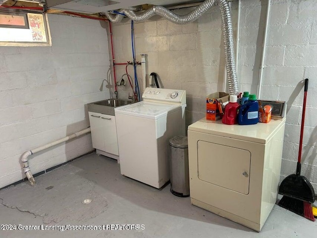 clothes washing area with washing machine and dryer and sink