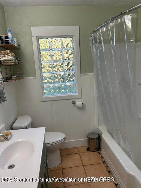 full bathroom featuring tile patterned floors, vanity, toilet, and shower / tub combo with curtain