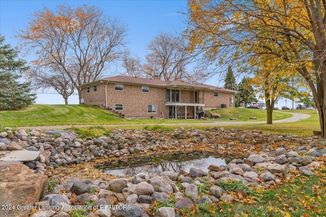 rear view of property with a sunroom and a yard