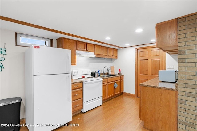 kitchen featuring sink, tasteful backsplash, crown molding, light hardwood / wood-style floors, and white appliances