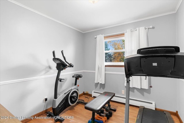 workout area with a baseboard heating unit, hardwood / wood-style flooring, and ornamental molding