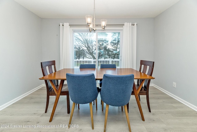 dining room featuring light wood-type flooring and an inviting chandelier