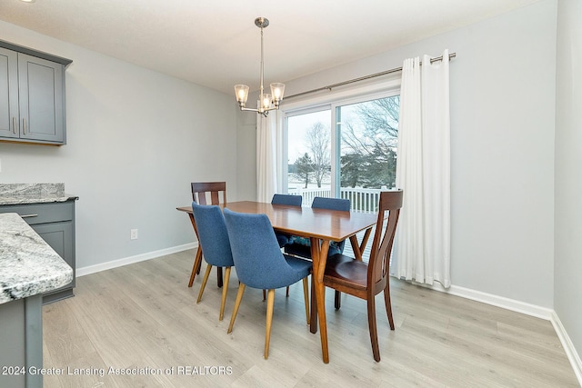 dining room with light hardwood / wood-style floors and an inviting chandelier