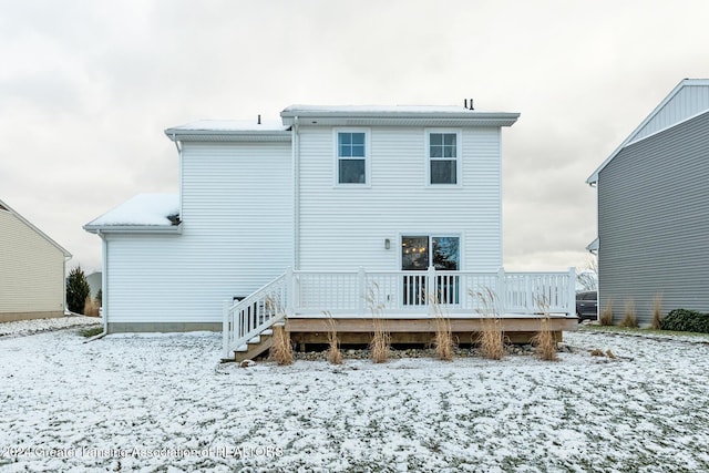 snow covered house featuring a deck