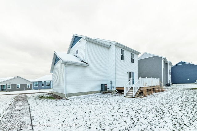 snow covered property with cooling unit and a deck