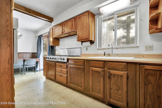 kitchen featuring beam ceiling, sink, and stainless steel gas cooktop