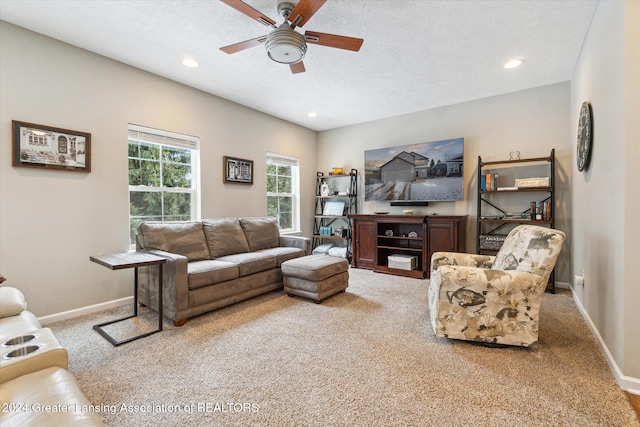 carpeted living room with ceiling fan and a textured ceiling