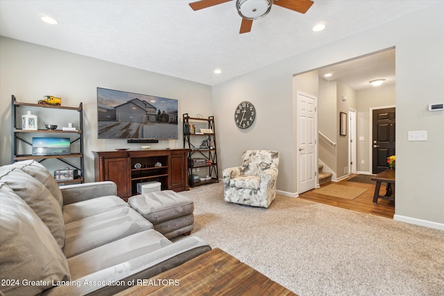 carpeted living room with ceiling fan