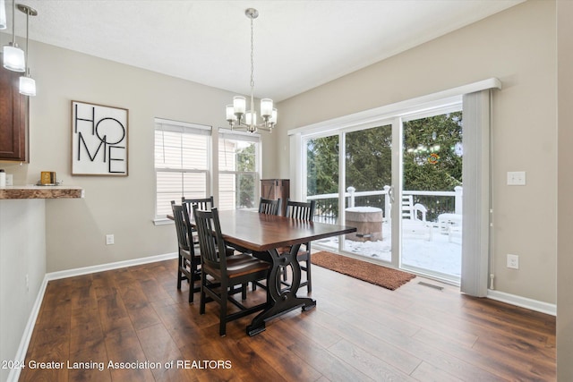 dining space with a notable chandelier and dark hardwood / wood-style flooring