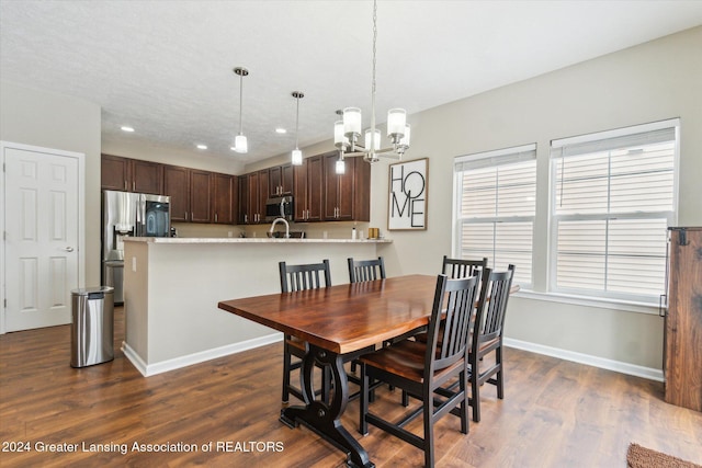 dining space with dark hardwood / wood-style floors and an inviting chandelier