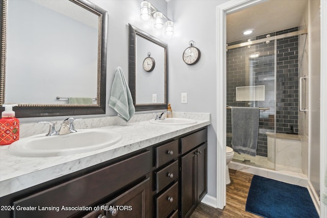 bathroom with walk in shower, toilet, vanity, and hardwood / wood-style flooring