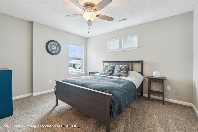 bedroom featuring carpet flooring, ceiling fan, and a textured ceiling