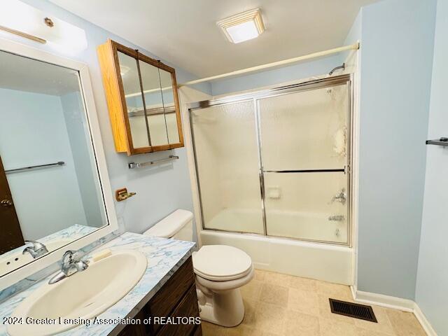 full bathroom featuring toilet, enclosed tub / shower combo, and vanity