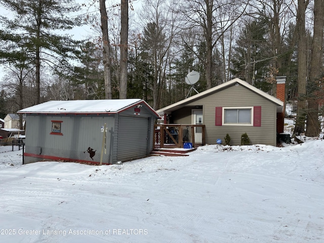 view of front of home featuring a garage and an outbuilding