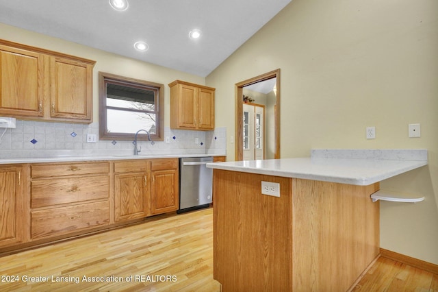 kitchen with kitchen peninsula, vaulted ceiling, light hardwood / wood-style floors, and stainless steel dishwasher