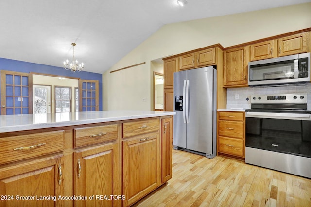 kitchen featuring decorative backsplash, stainless steel appliances, light hardwood / wood-style flooring, a chandelier, and lofted ceiling