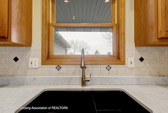 interior details featuring light stone countertops and sink