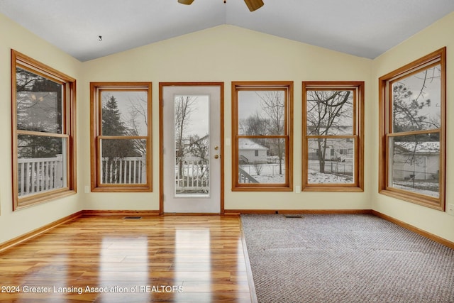 unfurnished sunroom with ceiling fan and vaulted ceiling