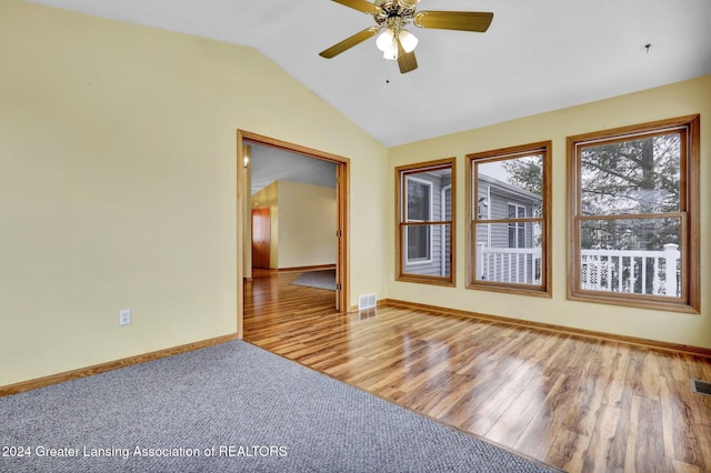 empty room with wood-type flooring, vaulted ceiling, and ceiling fan