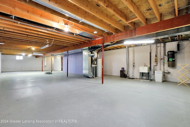 basement featuring heating unit and sink