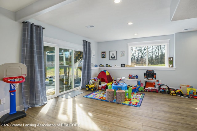 rec room with beam ceiling and wood-type flooring