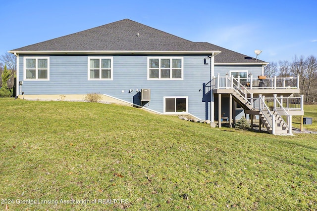 rear view of property with a deck and a lawn