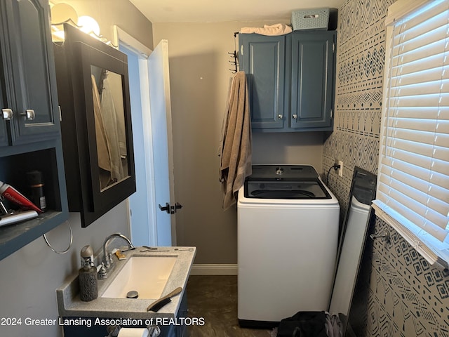 clothes washing area with washer / clothes dryer, sink, and cabinets