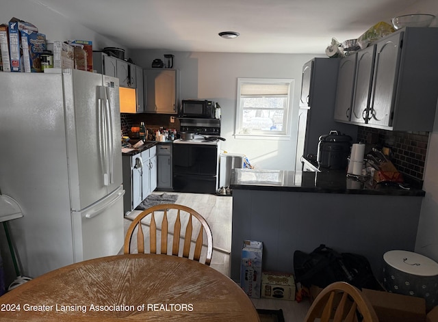 kitchen with black appliances, gray cabinetry, kitchen peninsula, and backsplash