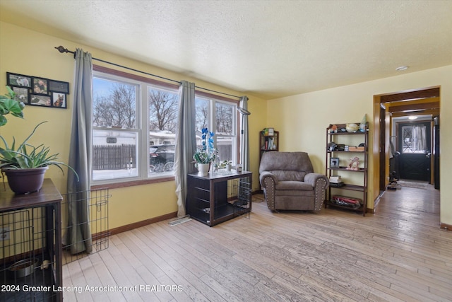 sitting room with a textured ceiling and light hardwood / wood-style floors