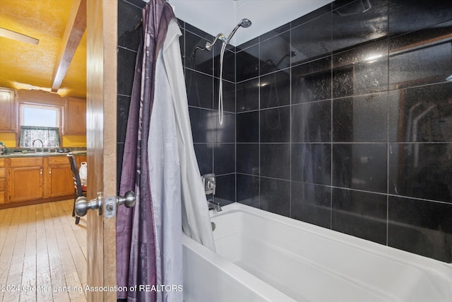 bathroom featuring vanity, shower / bath combination with curtain, hardwood / wood-style flooring, and beam ceiling