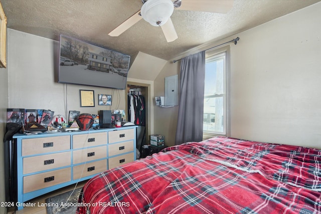 bedroom featuring ceiling fan, a closet, multiple windows, and a textured ceiling