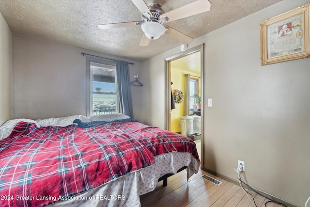 bedroom with ceiling fan, hardwood / wood-style floors, and a textured ceiling