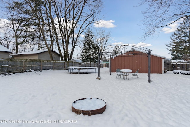 yard layered in snow featuring a trampoline