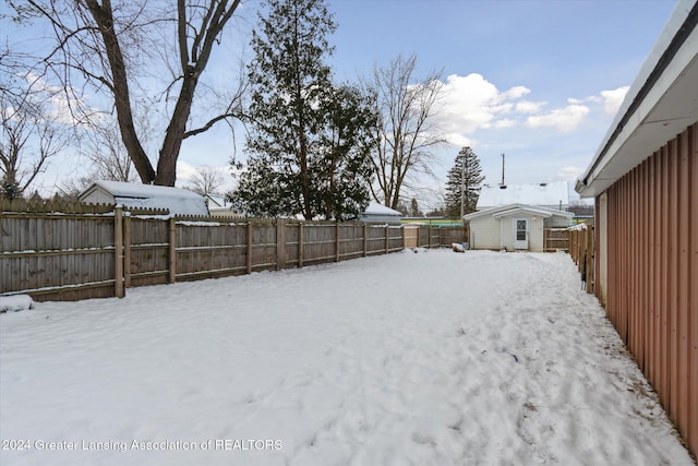 yard covered in snow featuring a shed