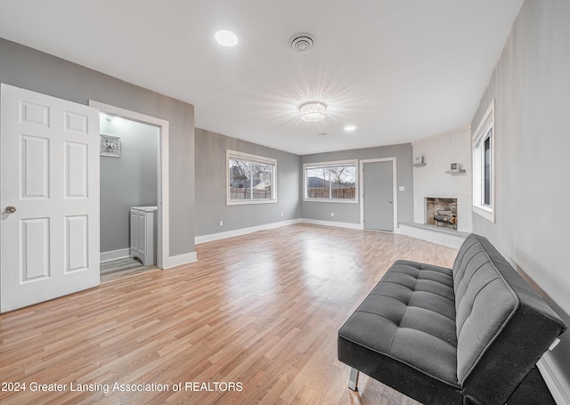 living room with a fireplace and light wood-type flooring