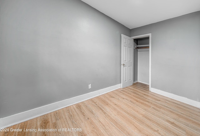 unfurnished bedroom featuring light hardwood / wood-style flooring and a closet