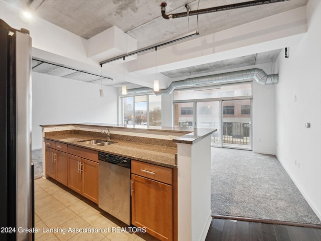 kitchen with light carpet, dark stone counters, hanging light fixtures, sink, and stainless steel appliances