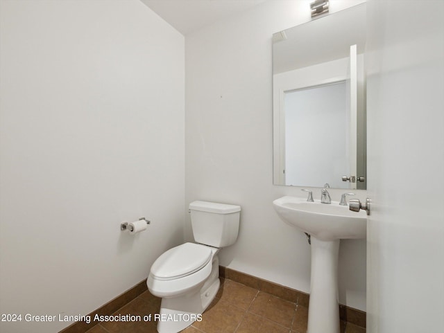 bathroom featuring tile patterned flooring, toilet, and sink